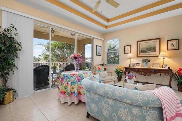 tiled living room featuring a tray ceiling and ceiling fan