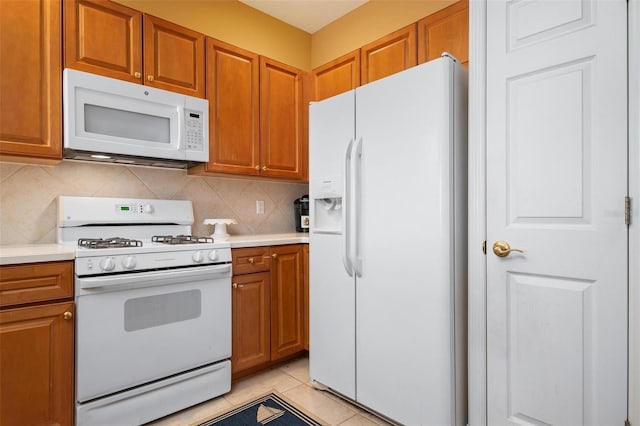 kitchen with white appliances, backsplash, and light tile flooring