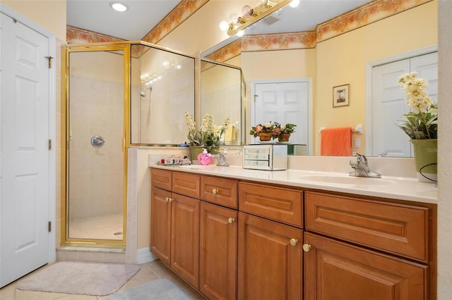 bathroom featuring a shower with shower door, dual vanity, and tile flooring