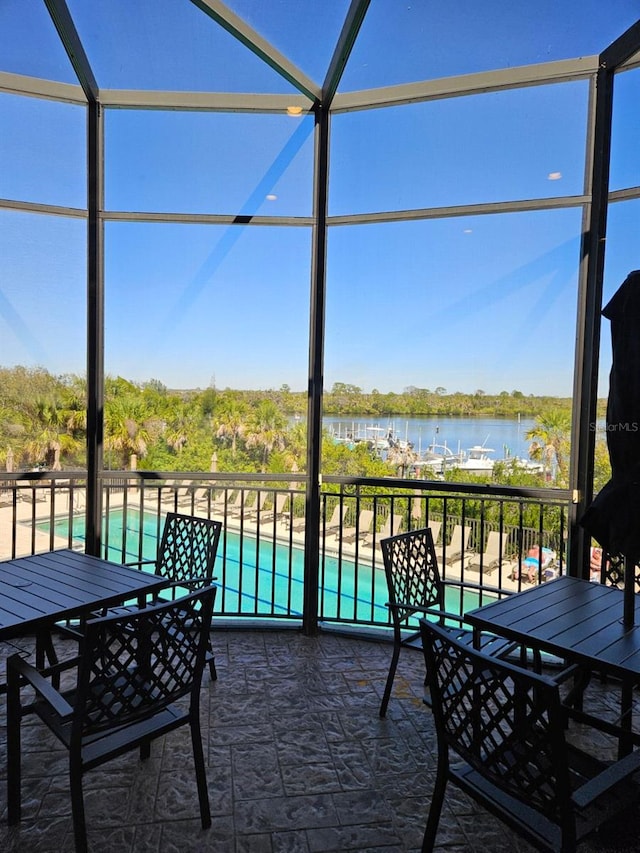 sunroom / solarium featuring a water view