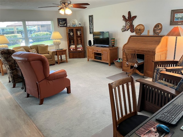 carpeted living room with ceiling fan