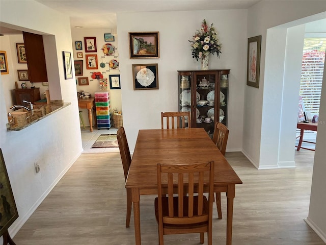 dining room with sink and light hardwood / wood-style floors