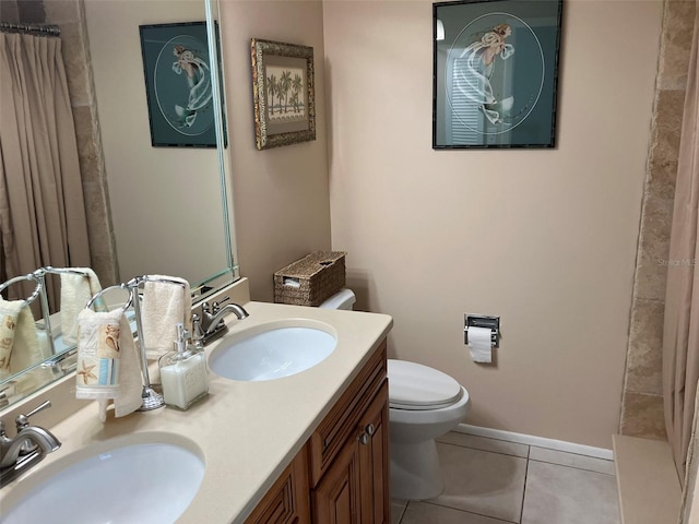 bathroom with tile floors, toilet, and dual bowl vanity