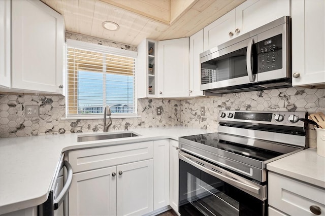 kitchen with white cabinets, sink, appliances with stainless steel finishes, and tasteful backsplash