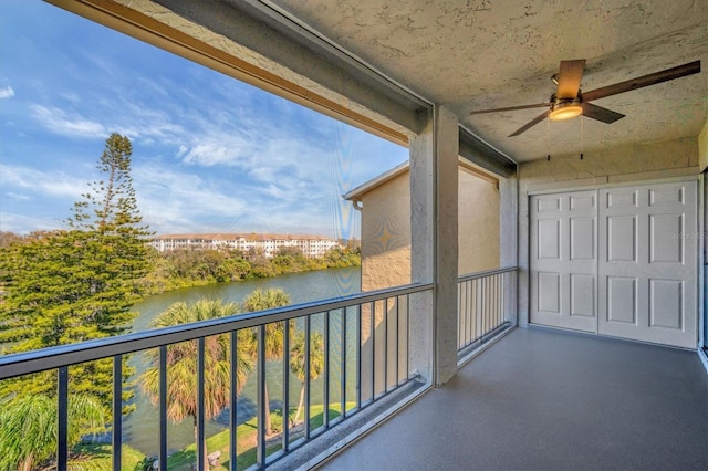 balcony featuring a water view and ceiling fan