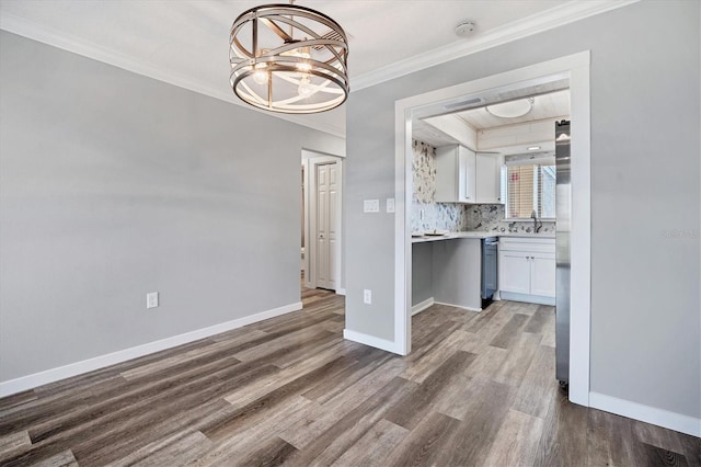 kitchen featuring white cabinetry, hardwood / wood-style floors, crown molding, and a notable chandelier