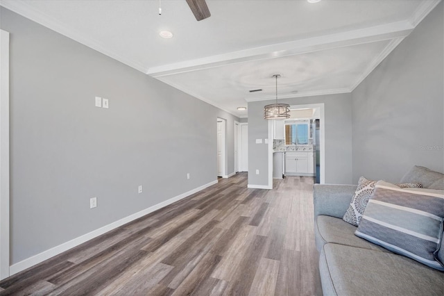 unfurnished living room featuring ceiling fan, beam ceiling, wood-type flooring, and ornamental molding