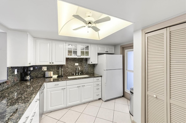 kitchen with sink, stainless steel dishwasher, white cabinets, and white fridge