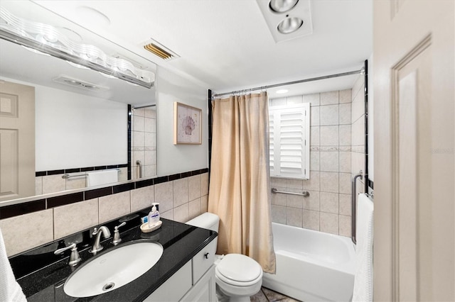 full bathroom featuring vanity, toilet, shower / bath combo with shower curtain, and tile walls