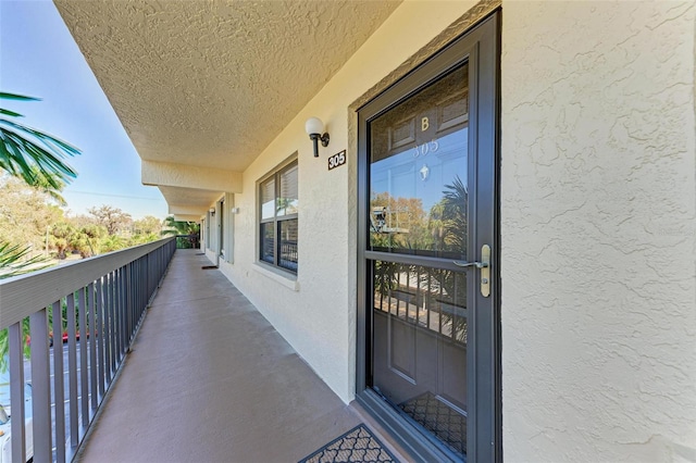 view of exterior entry with a balcony