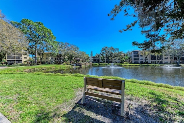 view of property's community featuring a lawn and a water view