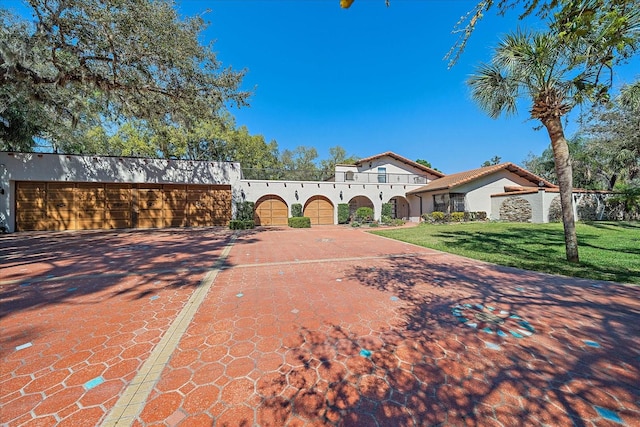 mediterranean / spanish-style house with a garage and a front yard