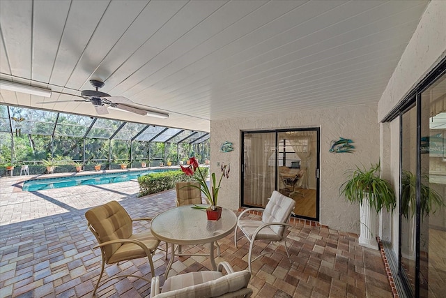 view of patio / terrace featuring ceiling fan and glass enclosure