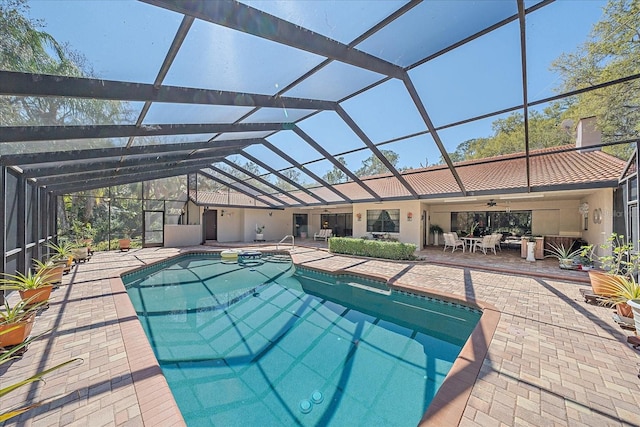 view of pool featuring ceiling fan, glass enclosure, and a patio area