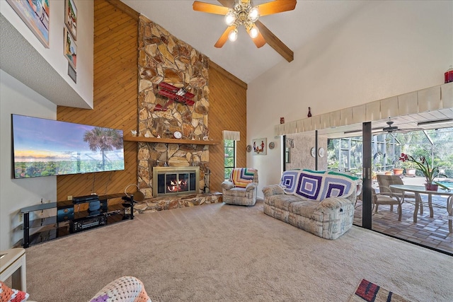 living room with a stone fireplace, carpet floors, ceiling fan, and wood walls