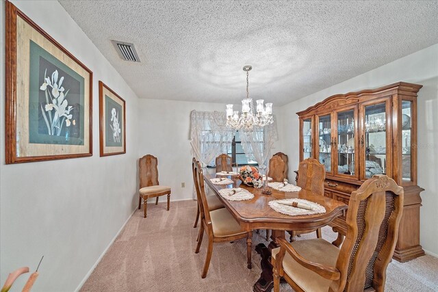 carpeted dining area featuring a notable chandelier and a textured ceiling