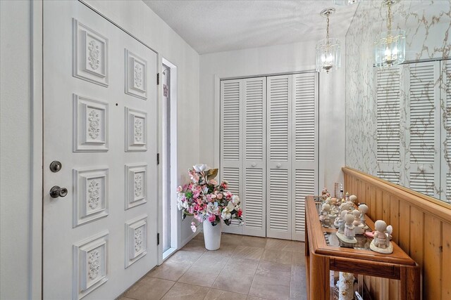 entrance foyer featuring a textured ceiling and light tile patterned floors