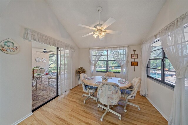 dining area with a wealth of natural light, vaulted ceiling, and light wood-type flooring