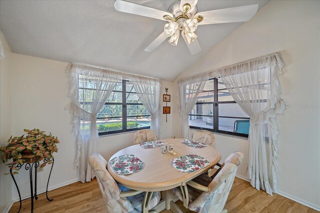 dining area with ceiling fan, lofted ceiling, and light hardwood / wood-style floors