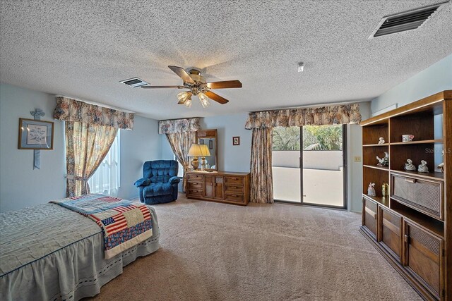 carpeted bedroom featuring ceiling fan, access to exterior, and a textured ceiling