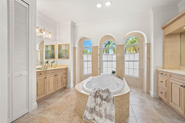 bathroom with tile patterned floors, vanity, ornamental molding, and tiled bath