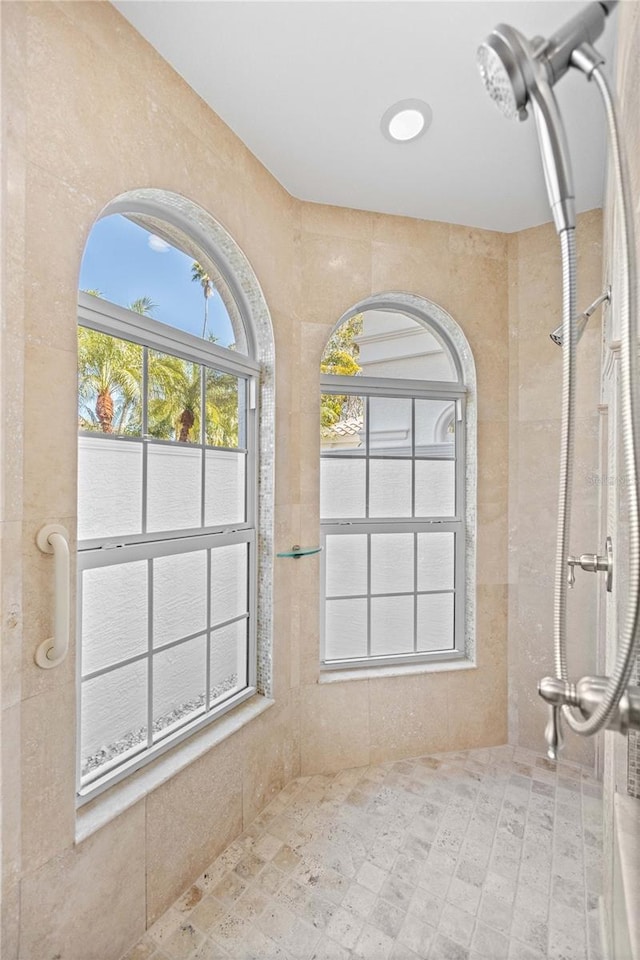 bathroom featuring tile walls and tiled shower