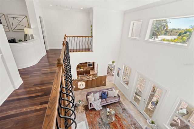 staircase featuring wood-type flooring and ornamental molding