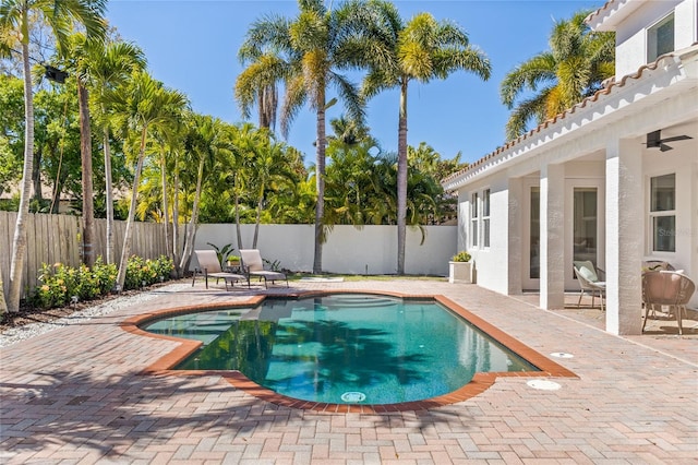 view of swimming pool featuring ceiling fan and a patio area