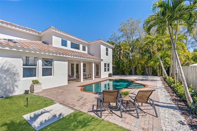 back of house with a patio area, a fenced in pool, and french doors