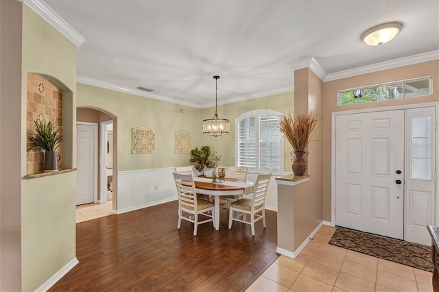 entrance foyer with a textured ceiling, a notable chandelier, hardwood / wood-style floors, and ornamental molding