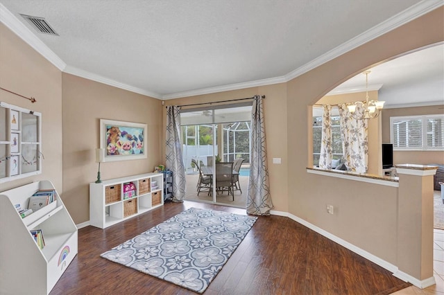 sitting room with a notable chandelier, crown molding, and dark hardwood / wood-style flooring