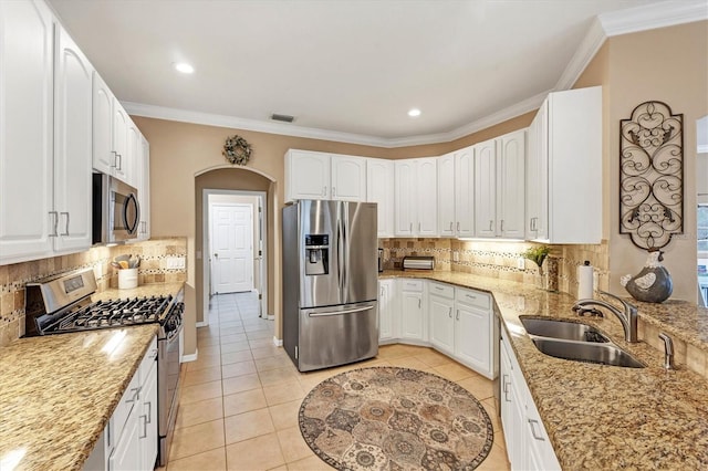 kitchen with white cabinets, decorative backsplash, appliances with stainless steel finishes, and light tile patterned floors