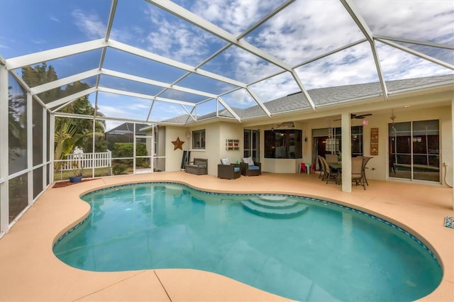 view of swimming pool featuring ceiling fan, a lanai, and a patio