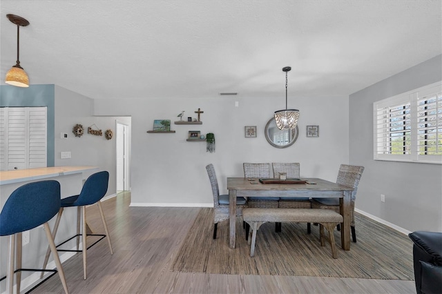 dining room with an inviting chandelier and hardwood / wood-style flooring