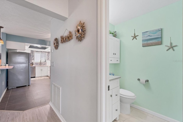 bathroom featuring tile floors, toilet, and vanity