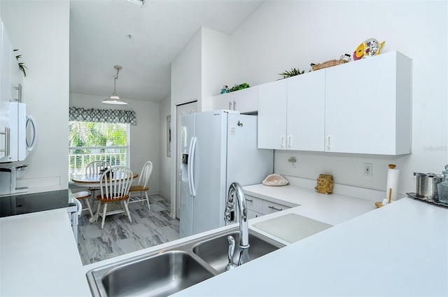 kitchen with white cabinets, decorative light fixtures, white appliances, and sink