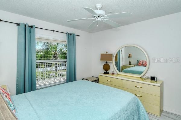 bedroom with a textured ceiling and ceiling fan