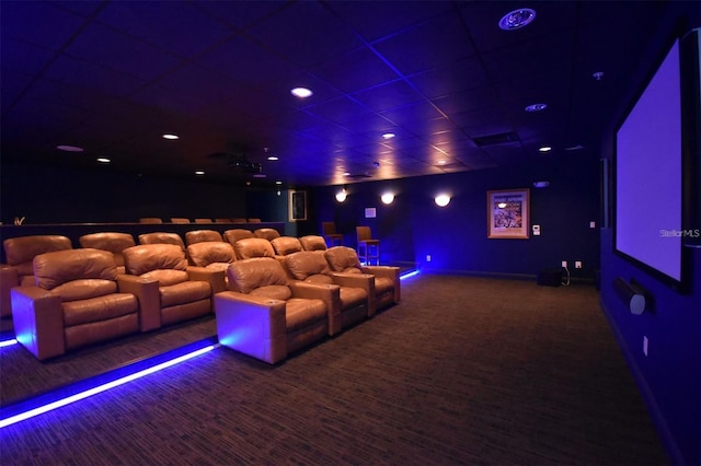 cinema with dark carpet and a paneled ceiling