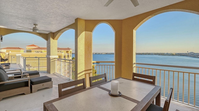 view of patio / terrace featuring a balcony, ceiling fan, and a water view