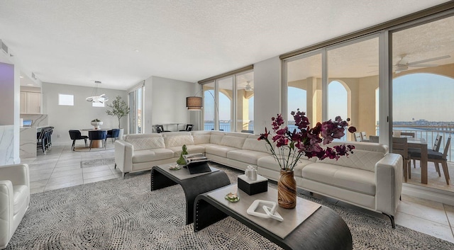 living room featuring light tile patterned flooring, a textured ceiling, and ceiling fan