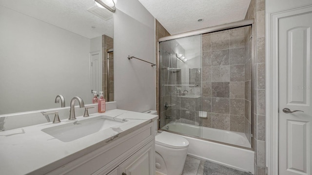 bathroom with vanity, toilet, bath / shower combo with glass door, and a textured ceiling