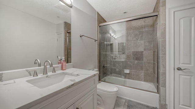 bathroom with toilet, a textured ceiling, vanity, and bath / shower combo with glass door