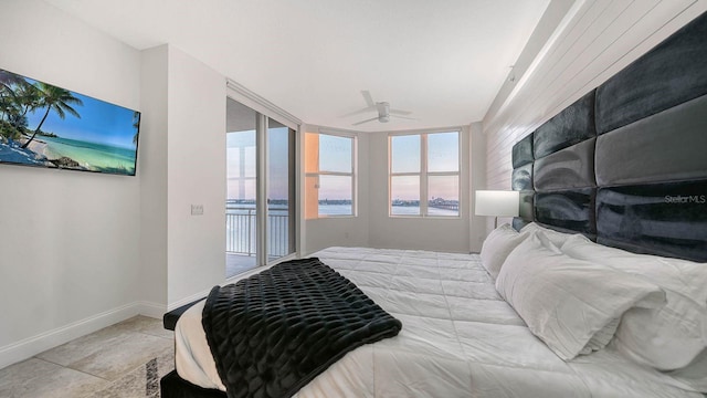 tiled bedroom with multiple windows, a ceiling fan, baseboards, and access to outside