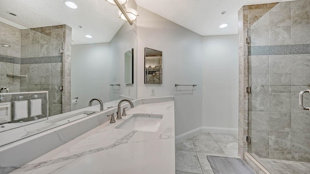 full bath featuring recessed lighting, baseboards, a textured ceiling, and a shower stall