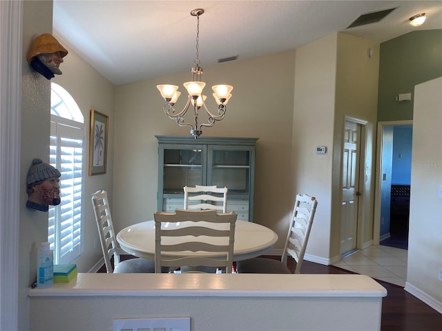 dining room with a notable chandelier, lofted ceiling, and light hardwood / wood-style floors