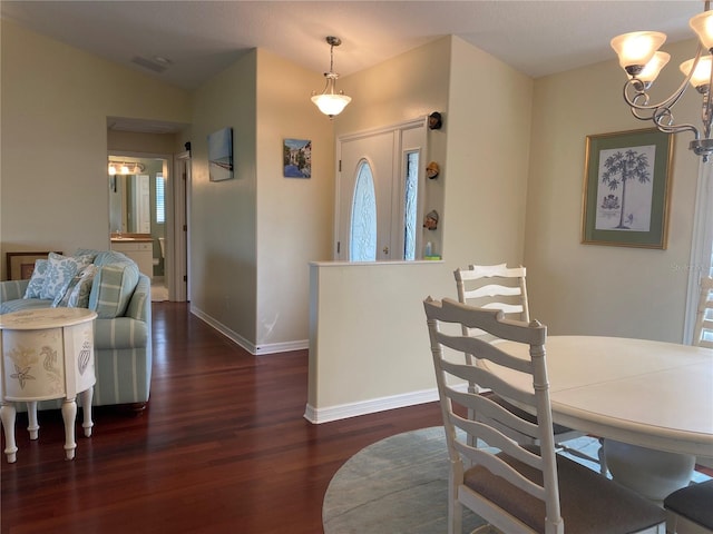 dining room featuring dark hardwood / wood-style floors, a chandelier, and lofted ceiling