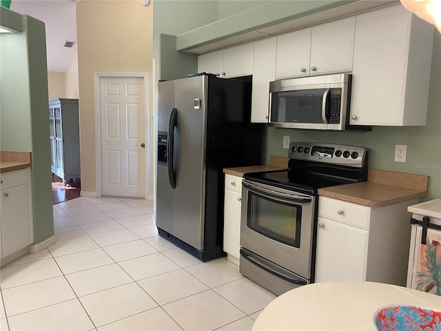 kitchen featuring white cabinetry, light tile flooring, and stainless steel appliances