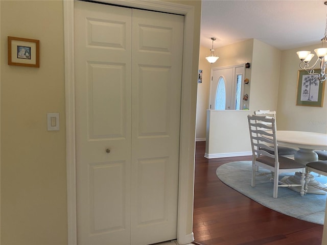 interior space with a notable chandelier and dark hardwood / wood-style flooring