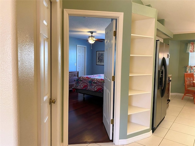 hall featuring light hardwood / wood-style floors and a textured ceiling