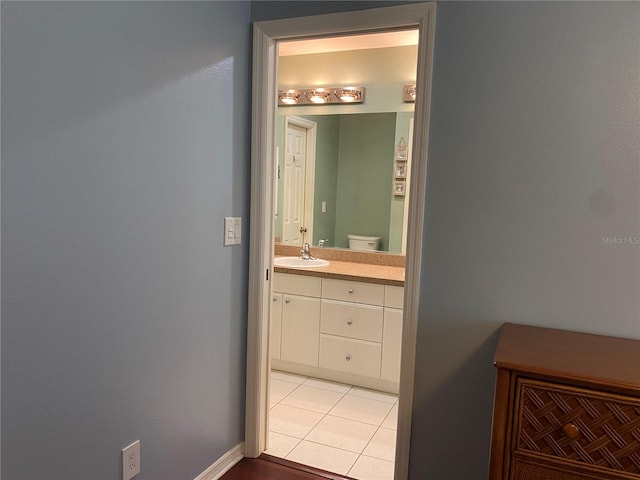 bathroom with tile floors, toilet, and vanity